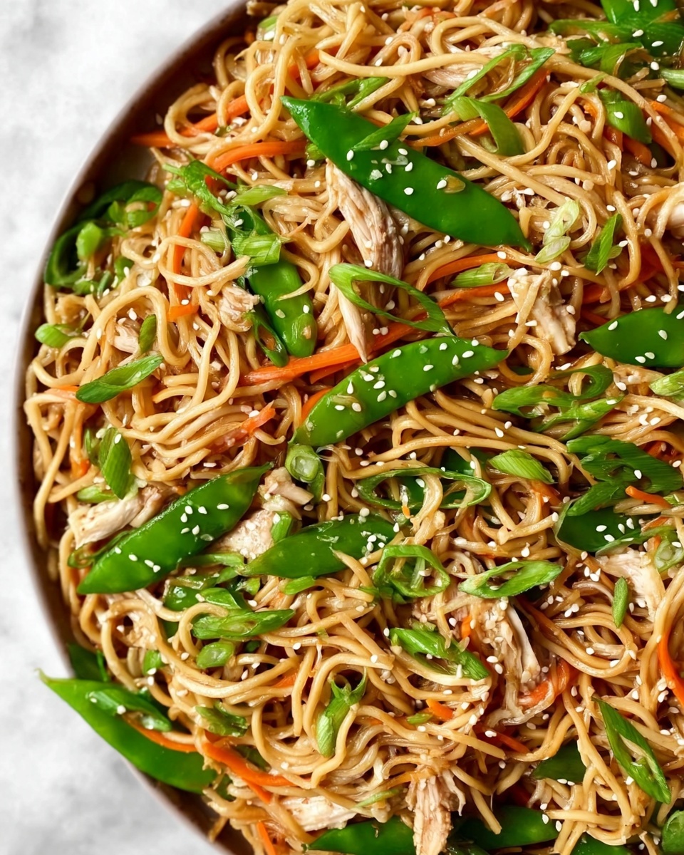 The dish is a close-up of a noodle stir-fry with three main layers visible. The first layer is light brown noodles twisted into small nests, covering most of the dish. The second layer is made of thin green snow peas and thin orange carrot strips scattered evenly across the noodles. The third layer has light beige thin strips of cooked meat mixed among the noodles and vegetables. On top, there are small white sesame seeds sprinkled all over and thinly sliced green onions resting lightly. The whole dish is on a white marbled surface photo taken with an iphone --ar 4:5 --v 7