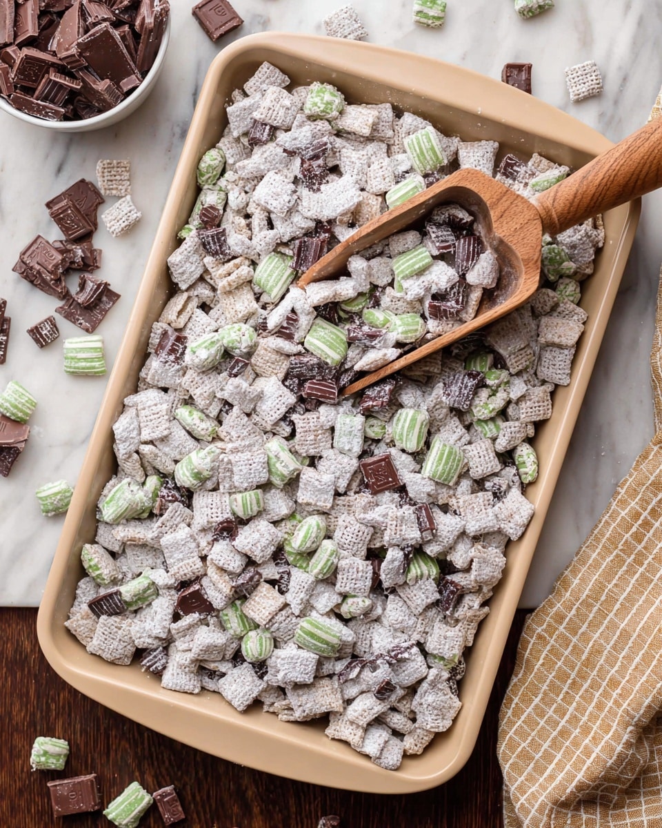 A large beige baking tray filled with small bite-sized pieces of cereal covered in white powdered sugar, mixed with pieces of pale green and dark brown striped candy and small squares of dark chocolate scattered on top; a wooden scoop with a smooth handle rests inside the tray holding some of the same mixture; lastly, a white marbled surface is underneath with some pieces of the candy and chocolate scattered on it, and a tan cloth with a square pattern is on the right side of the tray, photo taken with an iphone --ar 4:5 --v 7