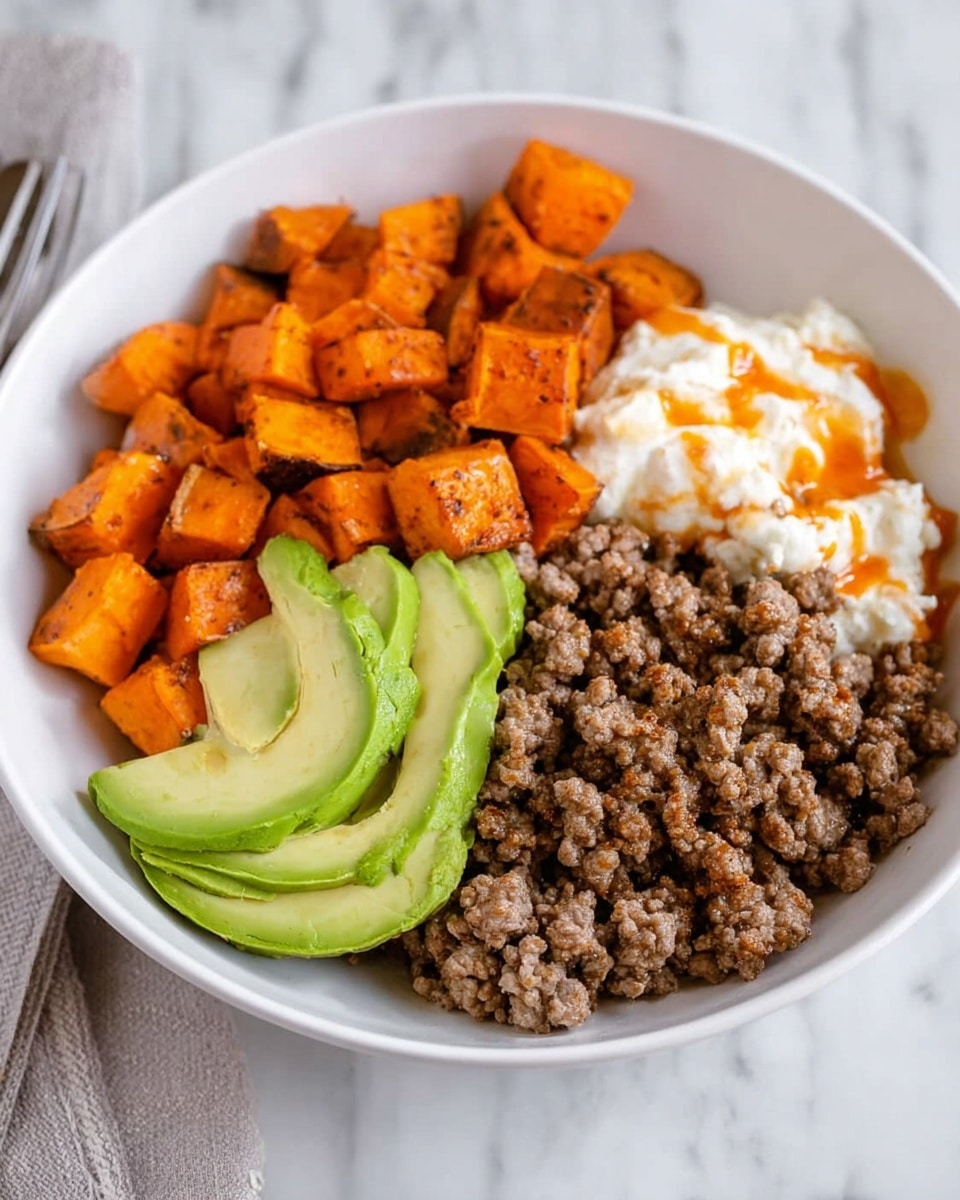 A white bowl holds three main layers arranged side by side: bright orange cubes of roasted sweet potato on the top left, light brown cooked ground meat on the right, and soft white cottage cheese with a small drizzle of orange sauce on the bottom left. In the center where the three sections meet, two slices of fresh green avocado are placed. The bowl is set on a white marbled surface. Photo taken with an iphone --ar 4:5 --v 7