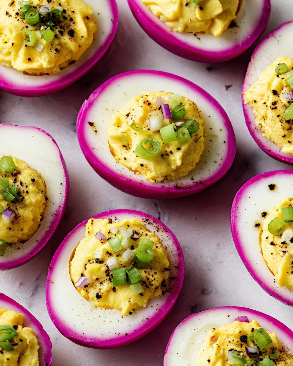 The image shows several halved eggs arranged closely on a white marbled surface. Each egg has three layers: the outer skin is a deep pinkish-purple, the middle is a smooth white layer, and the center is filled with a creamy yellow mixture, slightly textured and mounded above the white layer. The yellow filling is topped with small pieces of chopped green onion and sprinkled with coarse black pepper. The eggs are evenly spaced and displayed in a neat pattern. photo taken with an iphone --ar 4:5 --v 7