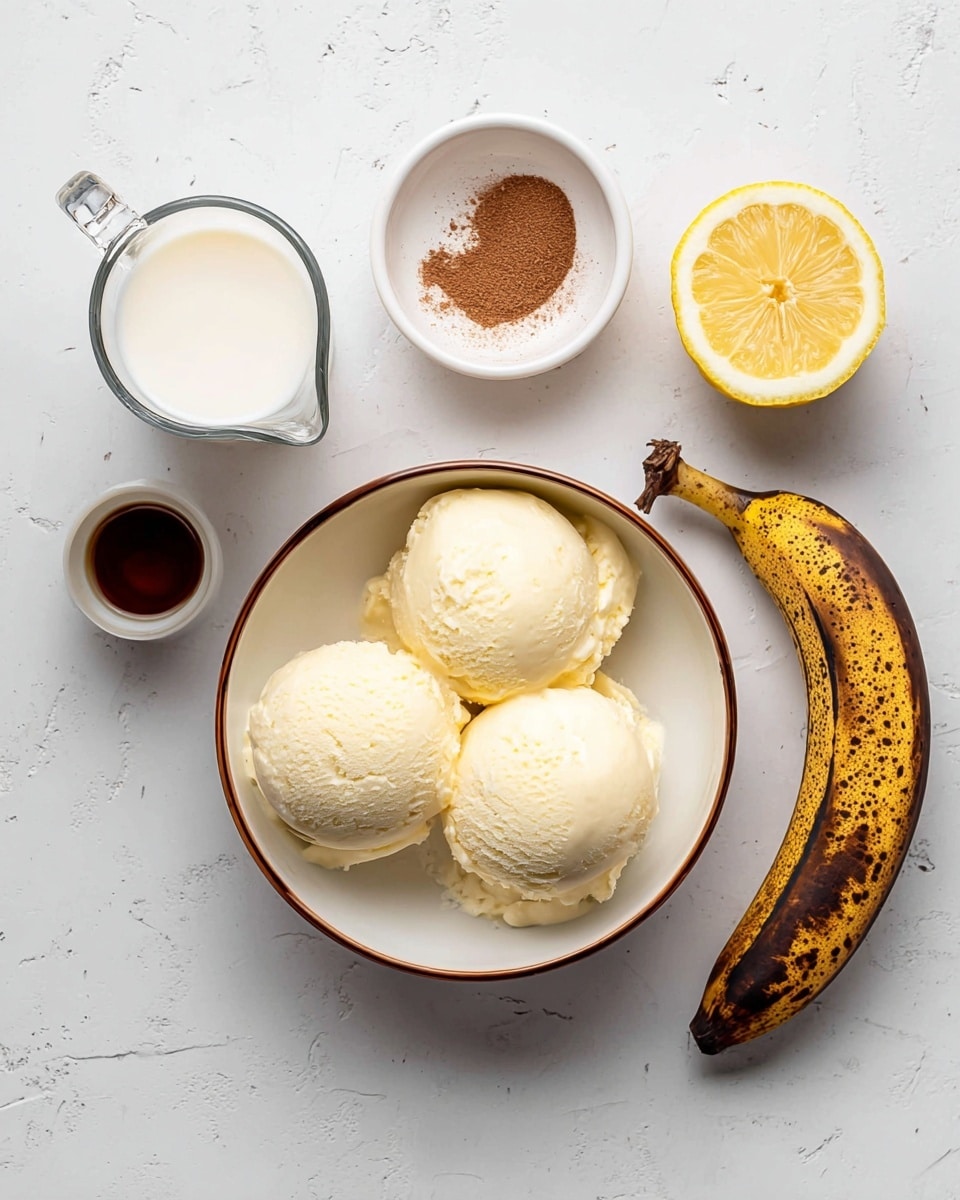The image shows three scoops of pale yellow ice cream in a round white bowl with a brown rim, placed on a white marbled surface. Above the bowl, there is a glass measuring cup filled with white milk, a small white bowl with a sprinkle of brown powder, a dark brown ripe banana, half a cut lemon showing its yellow flesh, and a small white cup with dark brown liquid. The setup gives a neat and simple look with a focus on light colors and soft textures. photo taken with an iphone --ar 4:5 --v 7