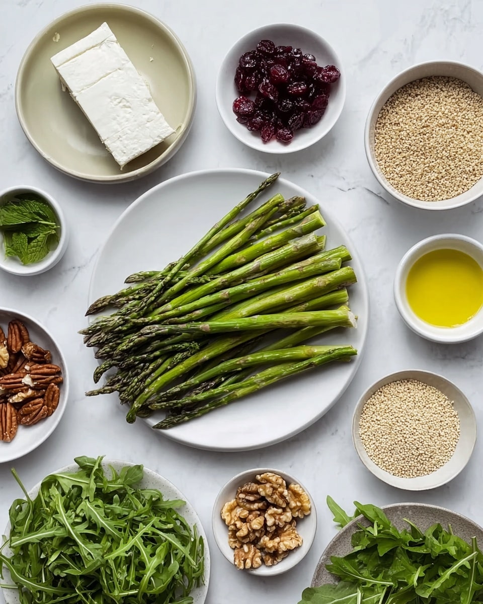 The image shows several small white bowls and plates arranged on a white marbled surface, each filled with different fresh ingredients. In the center, a white plate holds a neat bundle of green asparagus spears with a slightly rough texture at the tips. Around it, there is a plate with green leafy herbs including parsley and mint, and another plate filled with bright green arugula leaves with a delicate texture. Other small white bowls contain various items including a block of soft white cheese, a pile of deep red dried cranberries, a bowl of light brown walnuts, a bowl of golden olive oil, some mustard, and a portion of uncooked pale beige grains. The colors vary from deep green to white, red, brown, and golden yellow. The overall look is clean, fresh, and simple. photo taken with an iphone --ar 4:5 --v 7