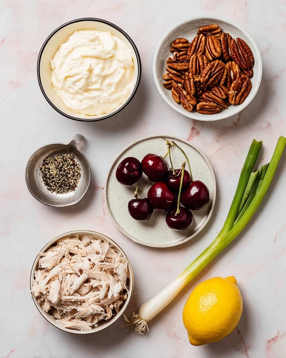 The image shows six different food items arranged on a white marbled surface. Starting from the top left, there is a white bowl with a thin black rim filled with creamy white mayonnaise. Next to it on the right, there is a white bowl filled with brown pecan nuts. In the middle, there is a round white plate with a small pile of dark red cherries with green stems. Below the cherries, a larger white bowl with a black rim holds shredded light-colored chicken. At the bottom left, a small metal dish contains mixed black and white peppercorns. On the bottom right side, a whole yellow lemon and a single long green onion with white root ends lie next to each other. Photo taken with an iphone --ar 4:5 --v 7