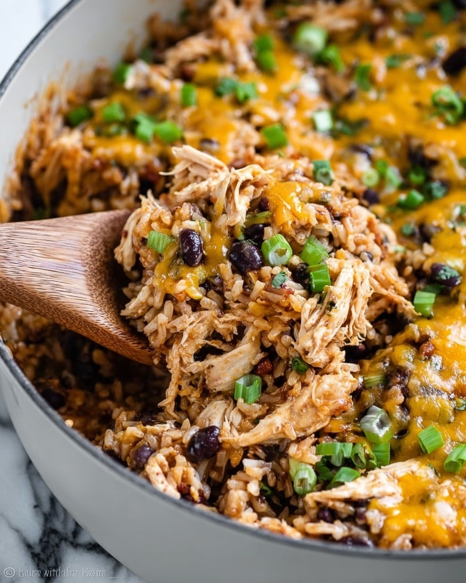 A close-up view of a white pan filled with a mixed dish showing three main layers: shredded light brown chicken on top, a layer of rice mixed with black beans underneath, and scattered melted orange cheddar cheese throughout. Small chopped green onions are sprinkled over the dish, adding a fresh green color contrast. A wooden spoon lifts some of the mixture, revealing the grainy texture of the rice and the softness of the chicken and beans. The pan sits on a white marbled surface. Photo taken with an iphone --ar 4:5 --v 7