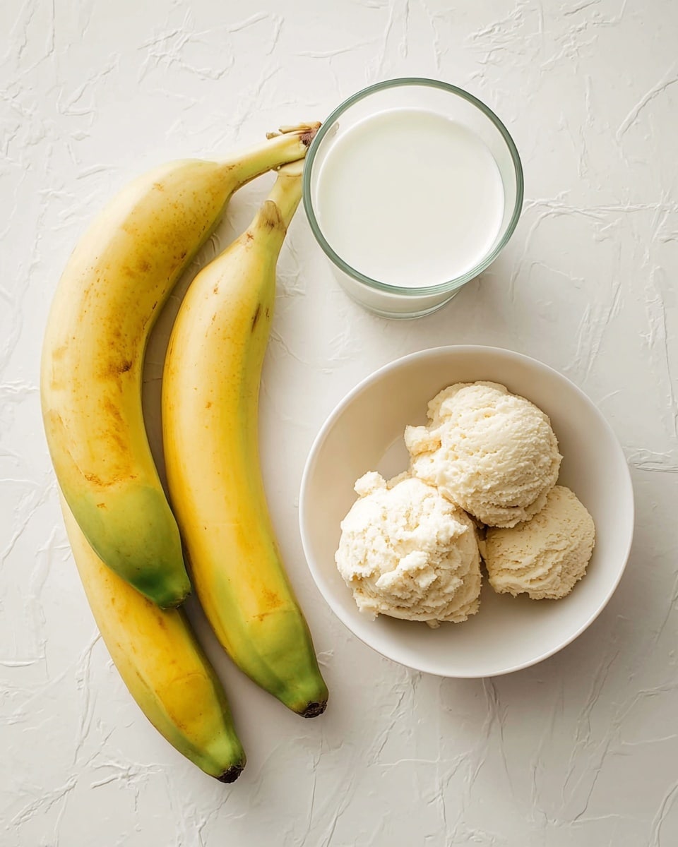 The image shows three yellow bananas with green tips placed on a white marbled surface, a clear glass filled with white milk positioned above the bananas, and a white bowl holding four scoops of light beige ice cream with a creamy texture positioned to the right side. The arrangement is simple and clean with soft natural light highlighting the colors and textures. Photo taken with an iphone --ar 4:5 --v 7