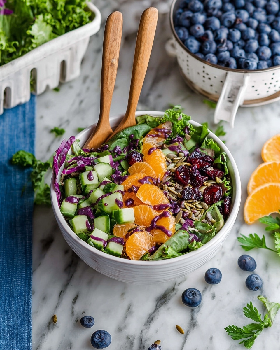 A white bowl with two wooden forks holds a colorful salad with three layers: at the bottom are green leafy vegetables mixed with purple leaves, the middle layer has chopped cucumber pieces, and the top layer is scattered with bright orange mandarin slices, dark blueberries, and red dried cranberries, all mixed with sunflower seeds and drizzled with a purple dressing. Around the bowl are loose salad leaves, fresh parsley, and a few blueberries on a white marbled surface. In the background, there is a white container full of blueberries and a white salad spinner with leafy greens inside. Photo taken with an iphone --ar 4:5 --v 7