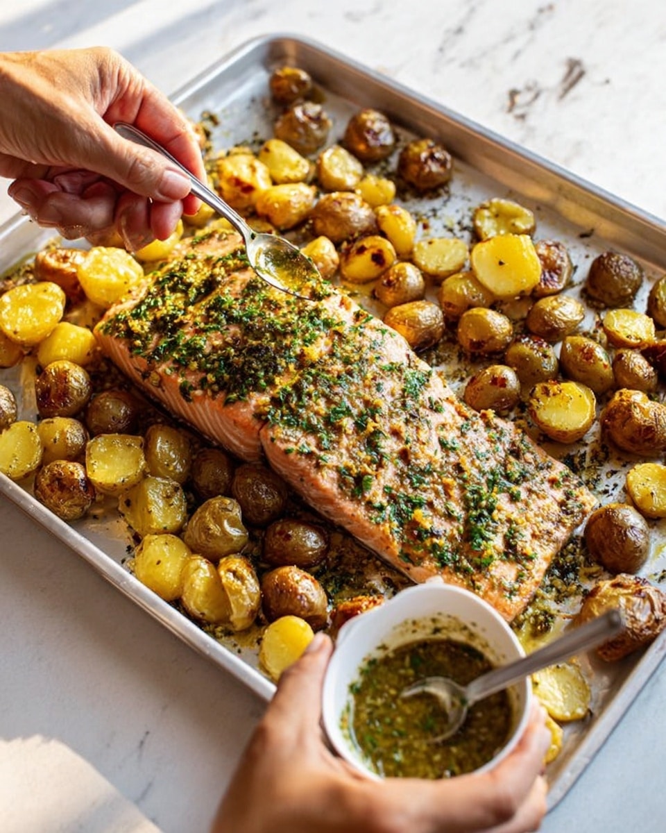The image shows a large silver baking tray filled with a thick piece of cooked salmon in the center, topped with green herbs and spices. Surrounding the salmon are small roasted potatoes, some cut in half, with browned, crispy skins and a golden-yellow inside. A woman's hand is holding a white bowl with green sauce, and another woman's hand is spooning the sauce over the salmon and potatoes. The tray sits on a white marbled surface, and the lighting is bright and natural. photo taken with an iphone --ar 4:5 --v 7