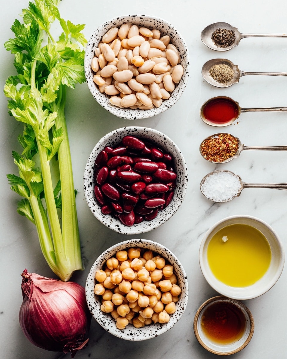 The image shows three small white bowls with black speckles arranged vertically, each filled with a different kind of beans: the top bowl holds light beige beans, the middle bowl has dark red beans, and the bottom bowl contains light brown chickpeas. To the right of these bowls, four small spoons are laid out vertically; the first spoon holds a dark amber liquid, the second spoon contains coarse black pepper, the third spoon has white salt crystals, and the fourth spoon holds a mix of brown spices. Also to the right, two small bowls are placed side by side: the top bowl contains golden yellow olive oil, and the bottom bowl holds a reddish-brown liquid with black specks. To the left of the bowls, there is a fresh light green celery stalk with leafy parsley leaves above it and a halved red onion below it. All items rest on a white marbled surface. photo taken with an iphone --ar 4:5 --v 7