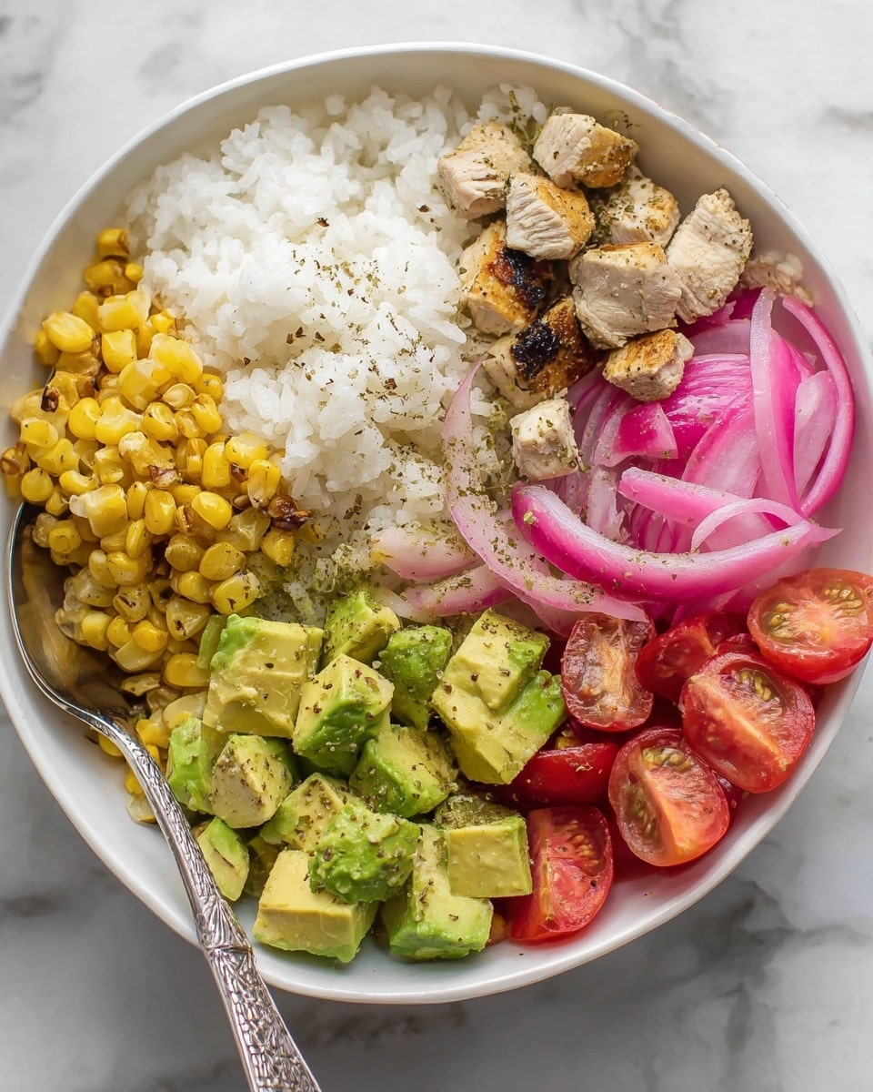 A white bowl with layers of food arranged in sections: at the top left, a mound of white rice with a slightly fluffy texture; to the right of the rice, small pieces of grilled chicken with a light brown and slightly charred surface; below the chicken, bright green chunks of avocado sprinkled with black pepper; next to the avocado, fresh halved red cherry tomatoes; above the tomatoes, thin slices of pink pickled onions forming a small pile; and to the left of the tomatoes, golden grilled corn kernels. There is a silver spoon resting inside the bowl on the left side. The bowl is placed on a white marbled surface. Photo taken with an iphone --ar 4:5 --v 7