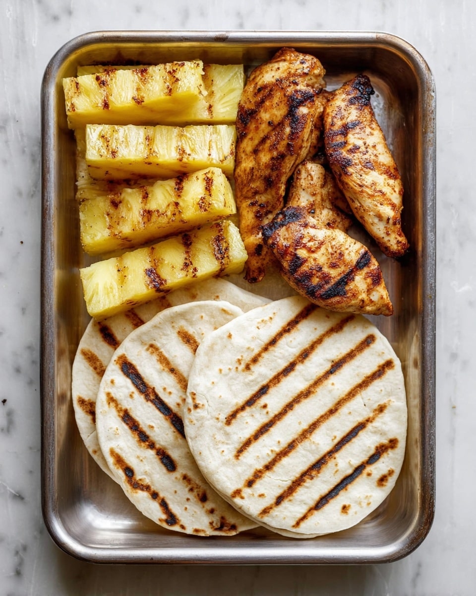 A metal tray holds four grilled soft white tortillas with brown grill marks on the bottom right, three pieces of grilled chicken with a golden-brown color and dark grill lines on the bottom left, and six thick pieces of grilled pineapple with yellow color and dark grill marks placed along the top half of the tray. The tray is placed on a white marbled texture. photo taken with an iphone --ar 4:5 --v 7