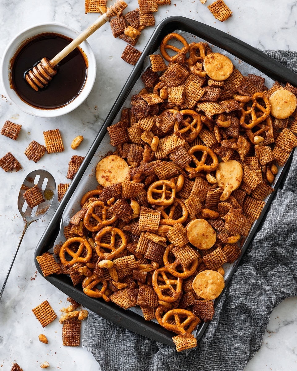 A white round tray lined with crumpled parchment paper holds a large pile of snack mix with many layers visible: small square cereal pieces with a grid texture in light brown, round pretzels with a smooth shiny surface in darker brown, curved thin chips with an uneven rough texture in golden brown, and round peanut nuts scattered throughout in light tan. The tray sits on a white marbled surface. In the background, a small white bowl filled with dark dipping sauce is partly visible. photo taken with an iphone --ar 4:5 --v 7