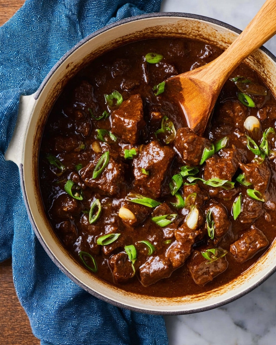 A white round pot filled with thick dark brown stew, showing chunky pieces of browned meat coated in the glossy sauce, small whole onions mixed in, and bright green onion slices sprinkled on top; a wooden spoon with a long handle is dipped into the stew, and a blue cloth is next to the pot, all placed on a white marbled surface photo taken with an iphone --ar 4:5 --v 7