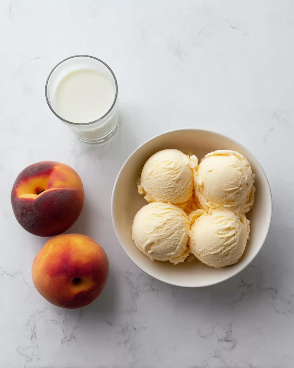 A white bowl holds five smooth scoops of pale yellow ice cream with a creamy texture. To the left of the bowl, there is a clear glass filled halfway with white milk. Below both the bowl and glass, two whole peaches sit side by side, displaying their soft orange and red skin. All items rest on a white marbled surface. Photo taken with an iphone --ar 4:5 --v 7