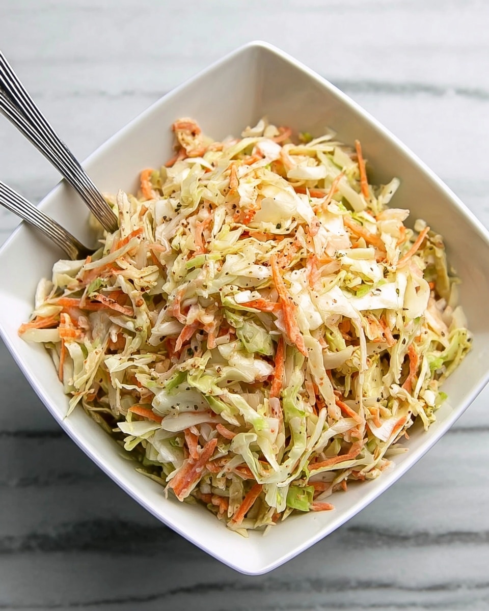A white square bowl filled with a mix of shredded cabbage and carrots in light green, pale orange, and white colors, showing fine, thin shreds all mixed together. Two metal spoons rest inside the bowl, slightly buried in the salad. The bowl sits on a white marbled surface. Photo taken with an iphone --ar 4:5 --v 7