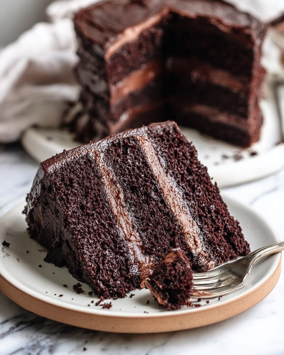 The image shows a thick slice of three-layer chocolate cake on a white plate with a light brown rim, placed on a white marbled surface. Each cake layer is dark brown and moist, separated by two smooth, light brown chocolate cream layers. The cake outside is covered in thick, glossy chocolate frosting, slightly shiny and textured. A silver fork holds a small piece of the cake in the front, close to the slice, with crumbs scattered around the plate. In the background, more cake slices are visible slightly blurred. Photo taken with an iphone --ar 4:5 --v 7