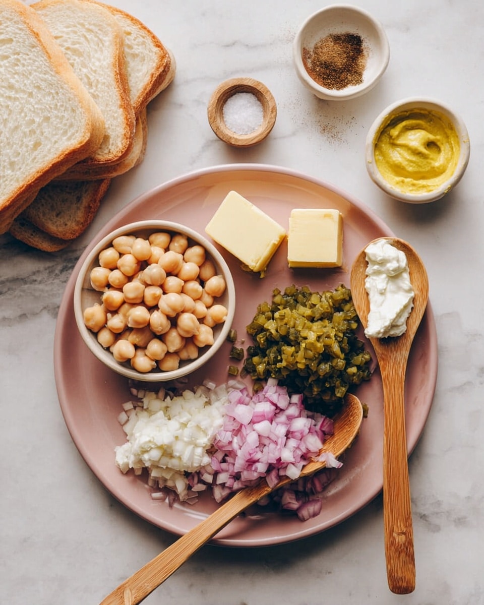 A pink plate sits on a white marbled surface, filled with several ingredients arranged separately: a small bowl full of light brown chickpeas placed on the left side, next to two small rectangular blocks of pale yellow butter above it. To the right, there is a pile of finely chopped green pickles and next to that, a mound of finely chopped red onions. Two wooden spoons rest diagonally on the plate, one holding a dollop of white cream and the other, a dollop of yellow mustard. To the left of the plate, several slices of white bread are stacked. Above the plate, two ceramic spoons—one filled with a dark brown powder and the other with salt—lie on the marbled surface, and a small white bowl filled with yellow mustard is partially seen on the right side. Photo taken with an iphone --ar 4:5 --v 7