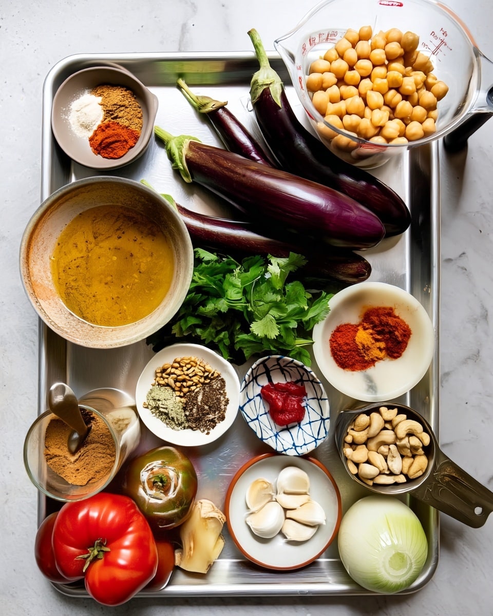 The image shows a metal tray on a white marbled surface holding cooking ingredients. On the top right, there is a clear measuring cup filled with chickpeas that are light tan and round. Four dark purple eggplants with green stems lie horizontally in the middle. Around them are fresh green cilantro leaves. To the right bottom, a small white bowl holds light brown cashew nuts. Below it is a pale yellow whole onion, and next to it, a small white bowl contains peeled garlic cloves. Toward the bottom left corner, there is a large ripe red tomato and a smaller green tomato, along with a small piece of fresh ginger root, light brown with rough texture. Near the top left, two small white bowls hold spices: one has white, brown, and red powders, and the other has red, orange, and brown powders. A small white bowl with a blue geometric pattern contains bright red tomato paste. In the bottom left, a glass holds brown powdered spices with a spoon inside. Finally, a light brown bowl near the left edge contains yellowish oil. photo taken with an iphone --ar 4:5 --v 7