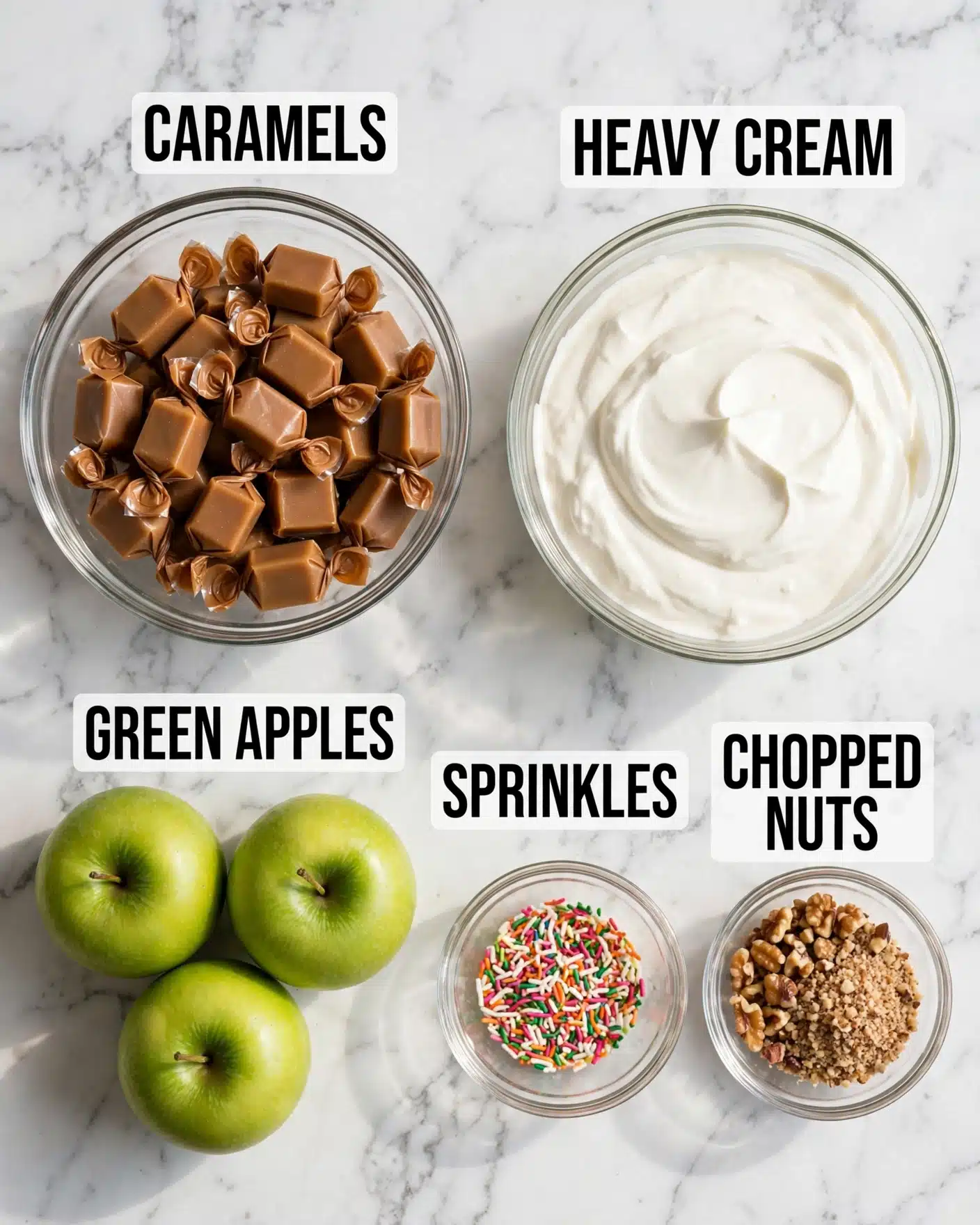 Easy Caramel Apples Recipe 4 The image shows a white marbled surface with five groups of ingredients arranged neatly. In the top left is a clear glass bowl filled with individually wrapped, soft brown caramel squares. To the right of the caramel is another clear glass bowl containing thick, white heavy cream. Below these, there are three bright green apples grouped together on the lower left. To the right of the apples are two small clear glass bowls side by side: the one on the left is filled with colorful thin sprinkles in pink, green, orange, white, and yellow, and the one on the right holds small chopped brown nuts. The ingredients are spaced evenly with clear labels in bold black text with a white background over each item. photo taken with an iphone --ar 4:5 --v 7
